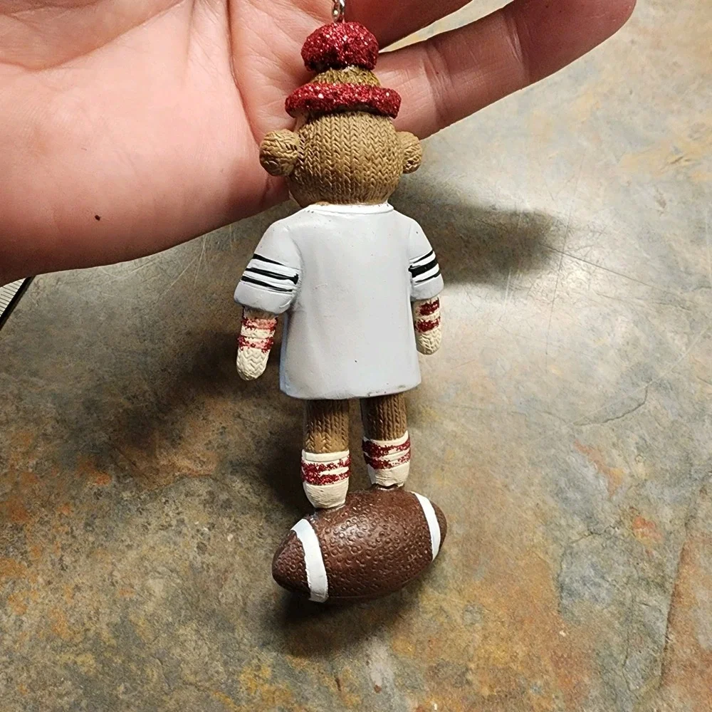 Christmas ornament sock monkey wearing Gray jersey standing on Football